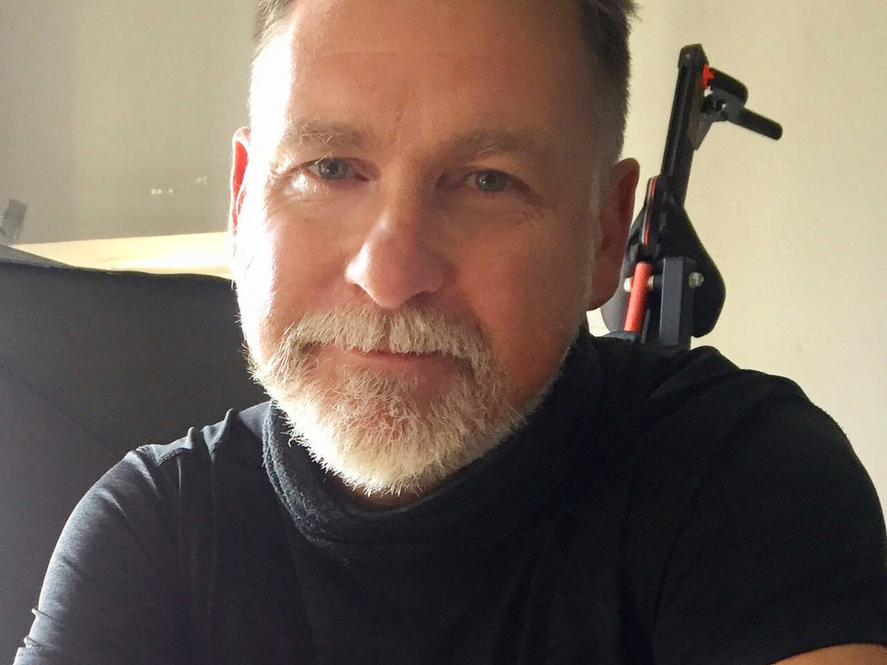 Close up headshot of David, photographer at Welsh Gold, with arms crossed in his studio.