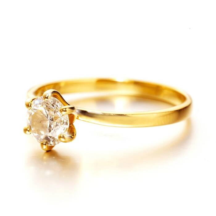 A brilliant-cut solitaire diamond secured by a six-prong setting on a slender, high-polish Welsh gold band.