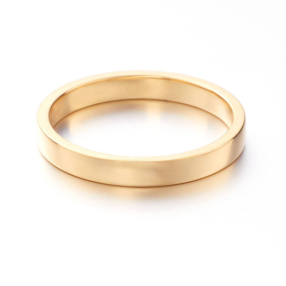 A polished gold wedding ring featuring a modern rectangular profile with flat edges and a smooth, level surface, showcasing the warm tones of authentic Welsh gold.