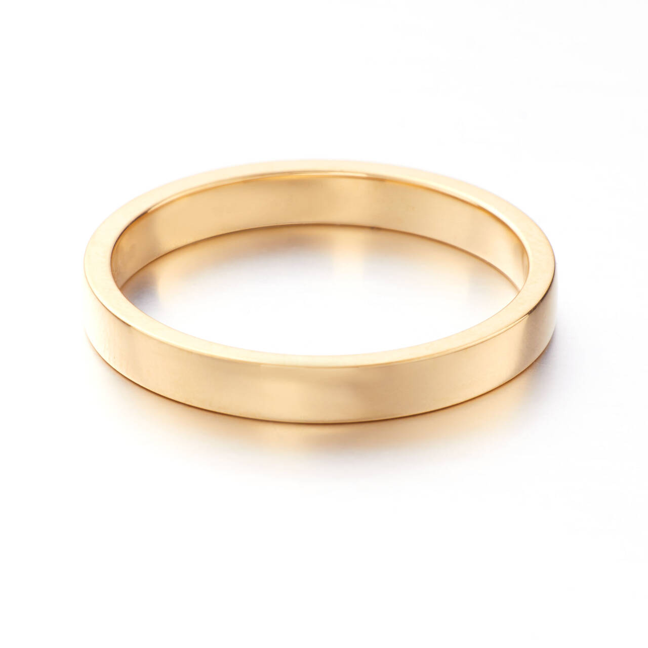 A polished gold wedding ring featuring a modern rectangular profile with flat edges and a smooth, level surface, showcasing the warm tones of authentic Welsh gold.