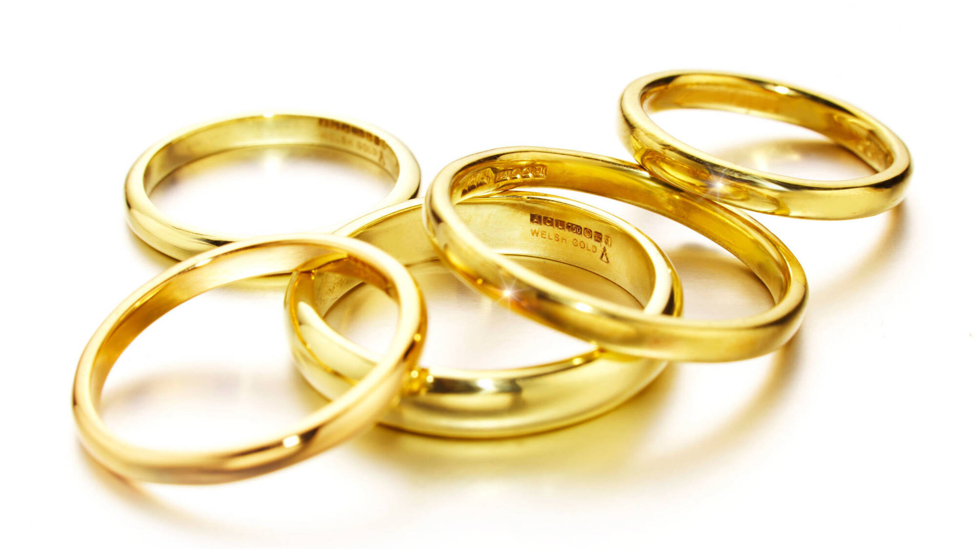 A selection of handcrafted Welsh Gold wedding bands featuring official hallmarking and a high-polish finish.