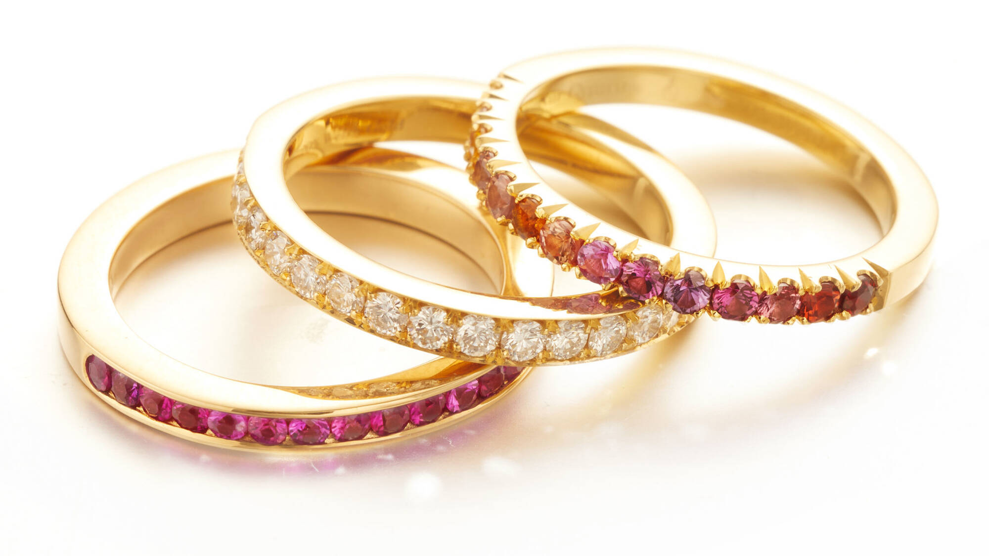 A trio of handcrafted Welsh gold eternity bands showcasing expert craftsmanship and vibrant gemstone settings.