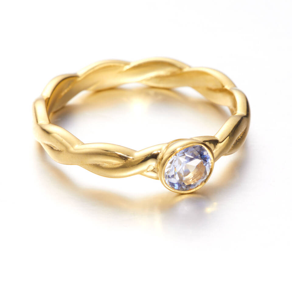 A Celtic design inspired woven engagement ring featuring 20% Welsh Gold and a clear blue sapphire centre stone in a bezel setting