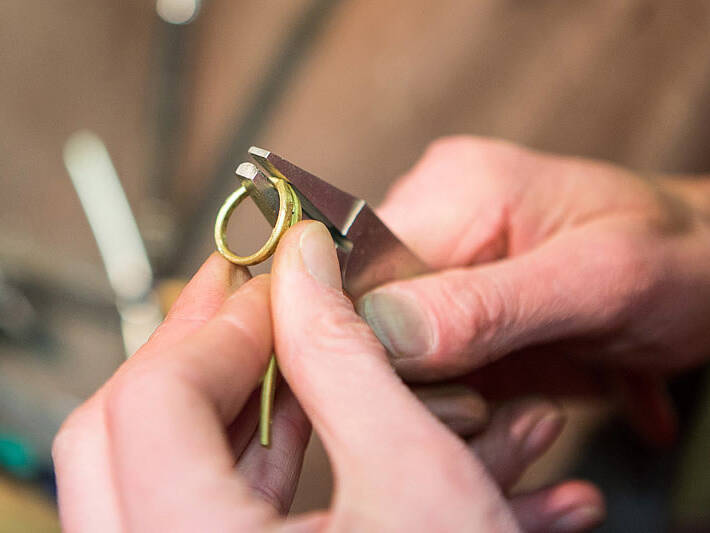 Handcrafting a Welsh gold wedding ring: an artisan uses specialised tools to form a 100% pure gold bar into a perfect circle.