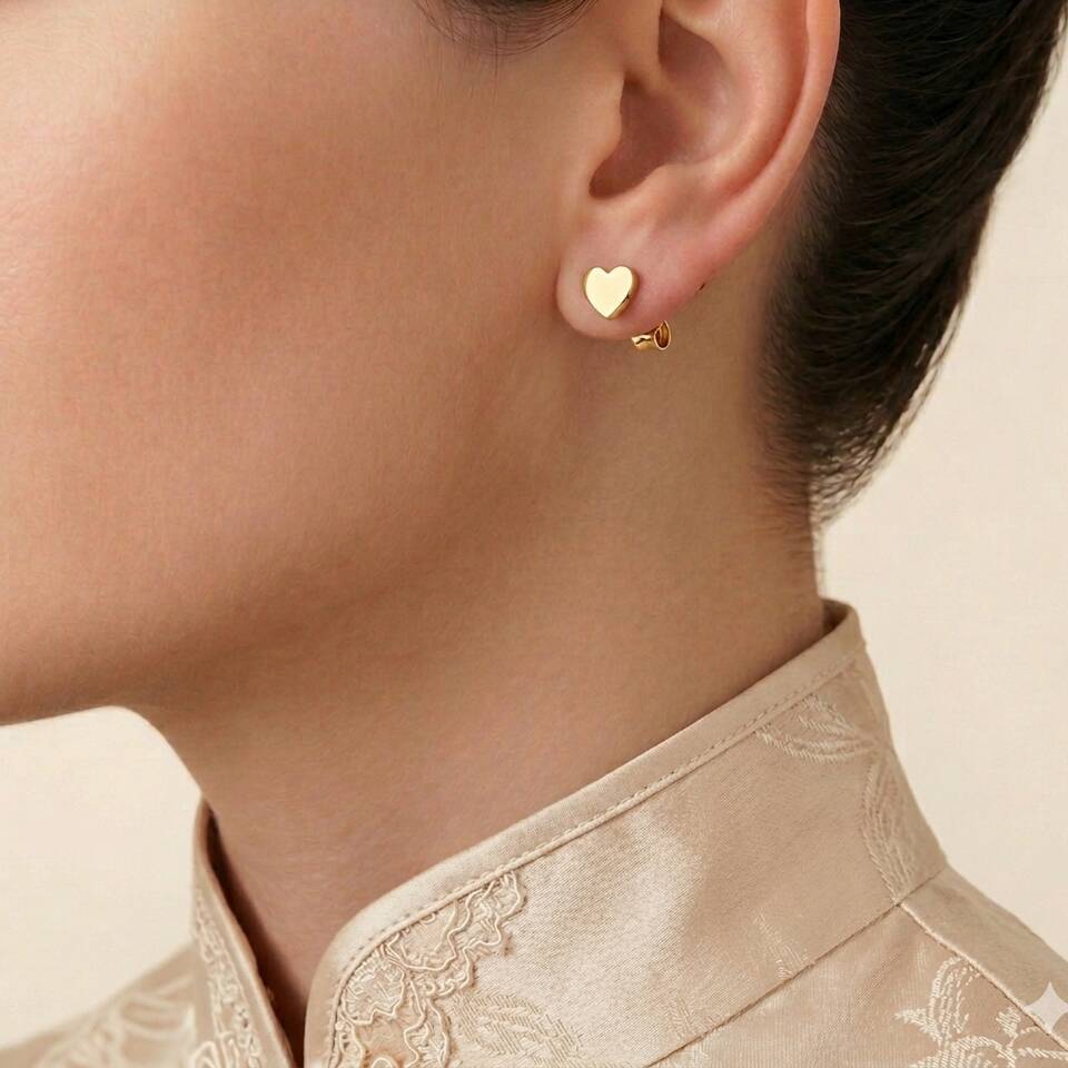 Close up side view of 18ct Eryri Welsh gold 4mm heart stud earring worn on an ear