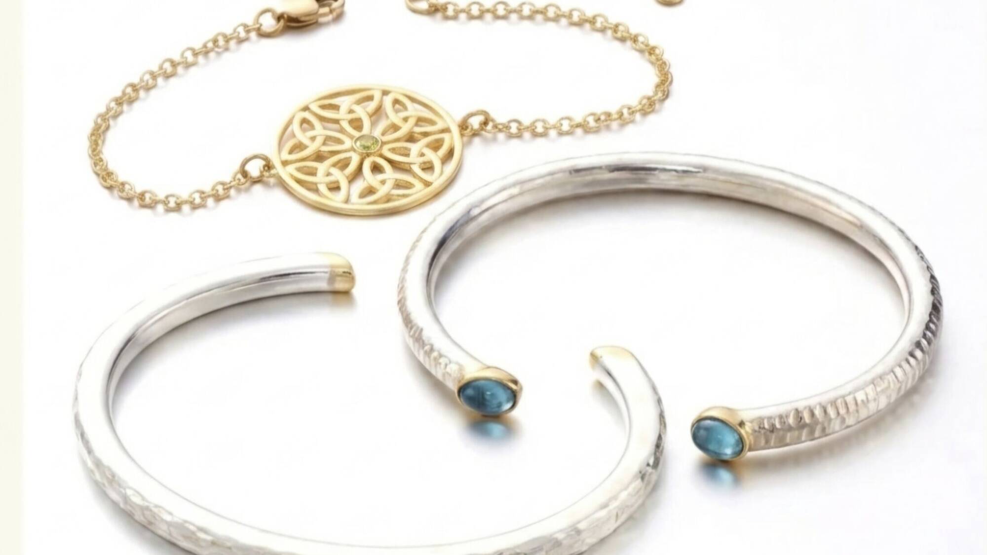 Selection of Welsh gold torques, open torc bangles, and gemstone bracelets on display