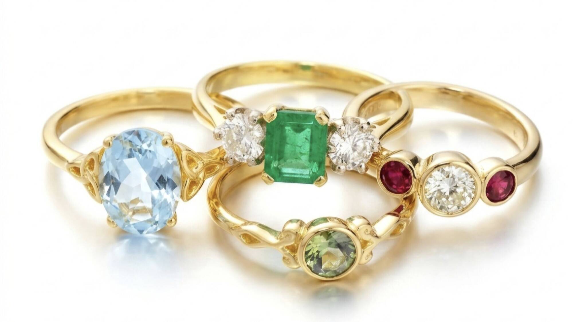 Arrangement of Welsh gold gemstone rings featuring sapphire, emerald, ruby, and aquamarine stones