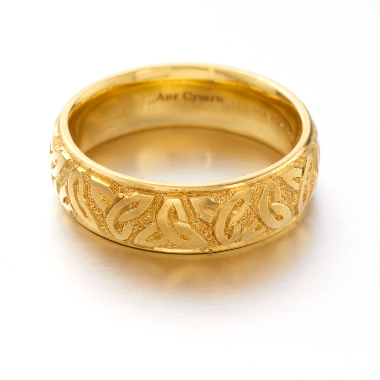 Studio view of a Welsh gold court section ring with hand-engraved Triquetra Trinity Knot design available in 5%, 20% and 100% Welsh gold